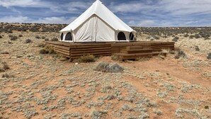 A white tent with two windows and a wooden platform in a desert landscape. - Luxury Glamping!  Near Horseshoe, Antelope Canyon, Lake Powell, Grand Canyon.' (Page)