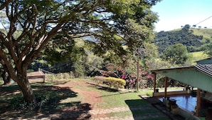 Un giardino con un gazebo, un vialetto e vista sulle colline.