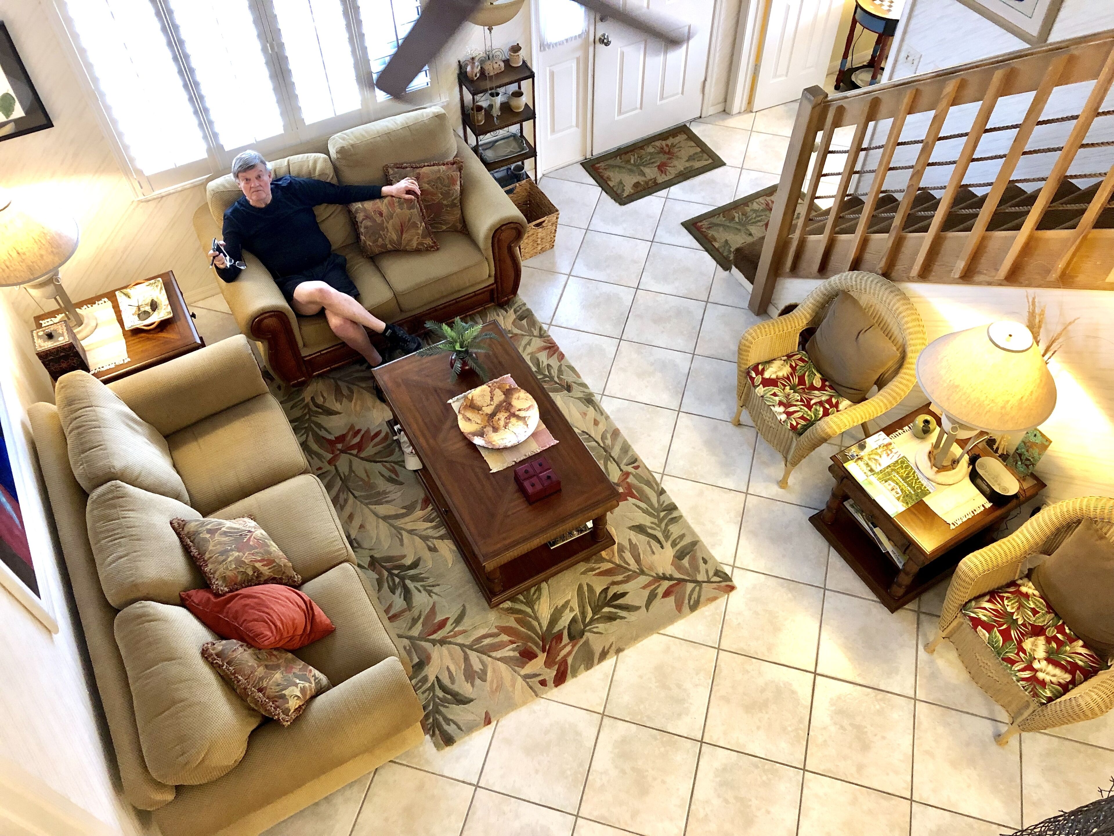 A spacious living room with a sofa, armchairs, a coffee table, and a dining table.