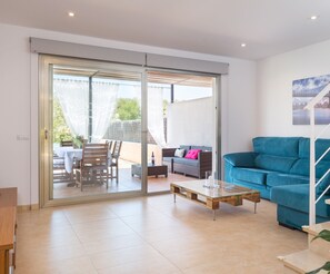Een moderne woonkamer met een glazen schuifdeur naar een terras.