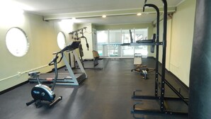 Une salle de sport équipée de tapis de course, de vélos elliptiques et de matériel de musculation.