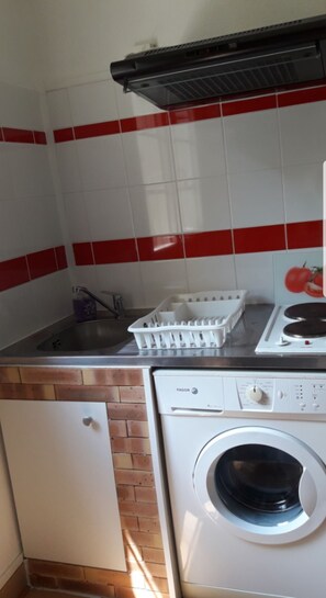 A compact kitchen with a sink, a stove, and a washing machine. - T2 apartment of 28 m2 (Bagnères-de-Luchon)