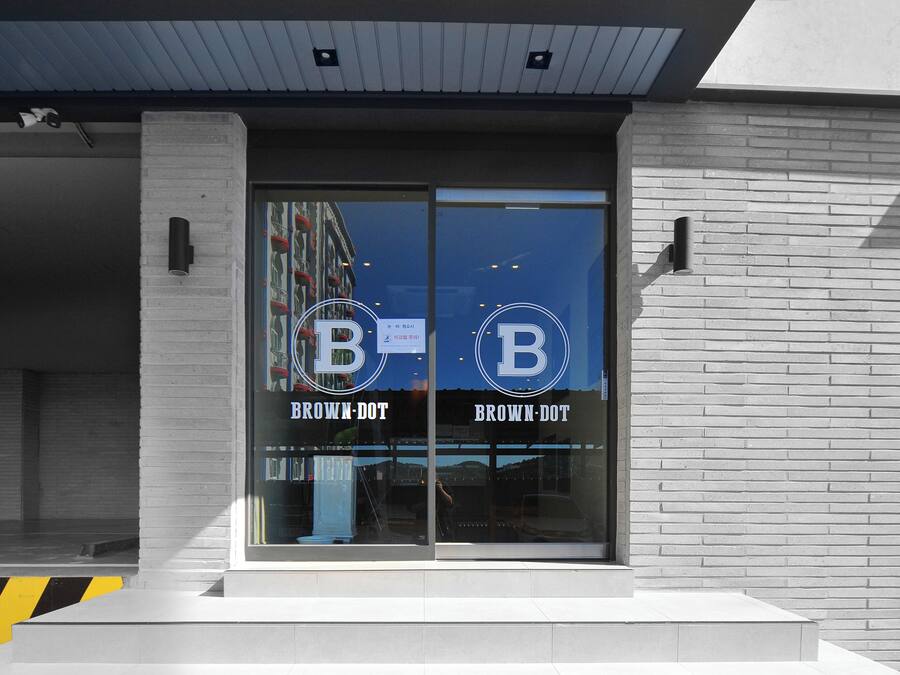 A building with a large glass entrance and the name "Brown-Dot" displayed on the glass.