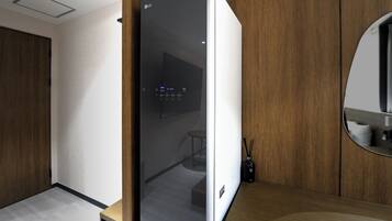 Eine moderne Küche mit einem eingebauten LG-Kühlschrank, Holzschränken und einem runden Spiegel über der Arbeitsfläche.