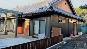 A traditional Japanese house with a tiled roof, wooden exterior, and a small porch area. - Stay, Experience, Discover!! Guest House Ilonggo -Filipino-Japanese Farm House- (Tsu)