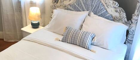 Une chambre à coucher avec un grand lit, un lustre et des rideaux.