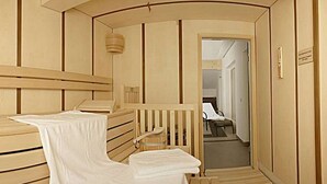 Une pièce avec un mur décoré de lambris en bois, un lit blanc et un banc en bois.
