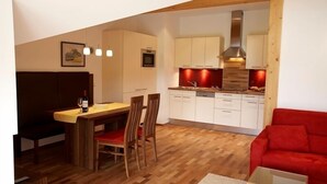 Un espace de vie compact comprenant un coin repas, une cuisine et un coin salon.