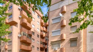 A multi-story building with balconies, satellite dishes, and a cafe named "Cafe Puente."