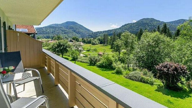 Un balcón con vistas a un paisaje verde y montañas.