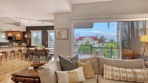 A spacious living room with a large sofa, dining area, and kitchen. - Ocean View of AMI | Hot Tub | IMG | 6 TVs | 2 King Beds (Bradenton)