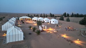 Um resort no deserto com iurtes, um edifício central espaçoso e uma estufa.