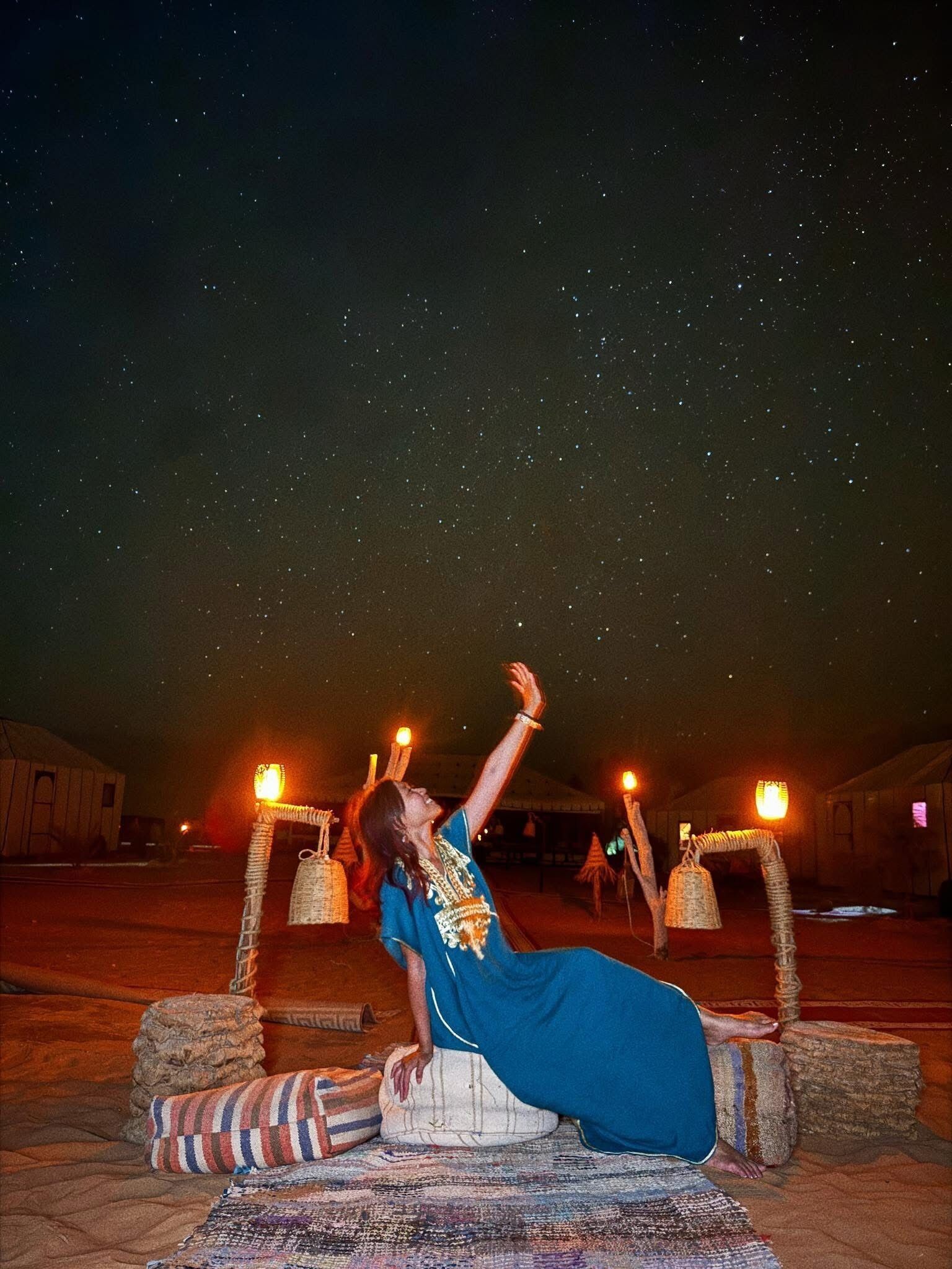 A person performing an acrobatic act outdoors at night with a starry sky in the background.