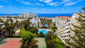 A resort with a pool, multiple buildings, and a view of the ocean. - 926 Precious Apartment, Beach front Sea view (Playa de las Américas)