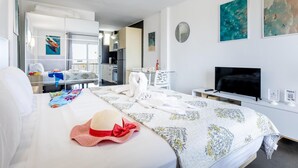 A hotel room with a bed, a TV, a desk, and a kitchenette. - 926 Precious Apartment, Beach front Sea view (Playa de las Américas)