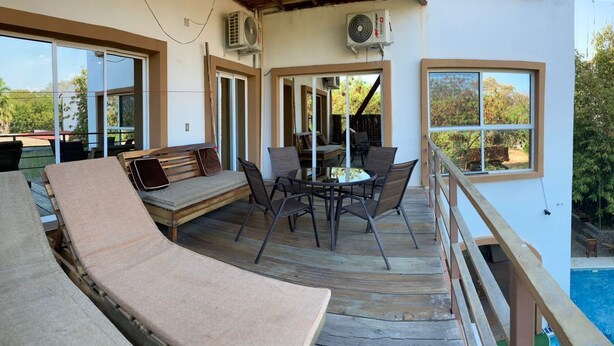 A covered outdoor area with a pool, wooden deck, and seating. - PALMAS DE CHAHUE 8 (1,100 SF) (Bahías de HUATULCO)