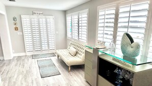 A modern living room with a beige sofa, a glass coffee table, and a decorative shell.