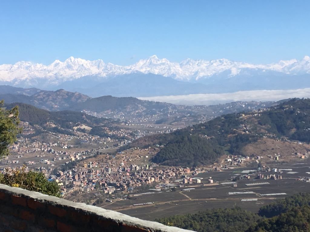Une vue panoramique d’une ville, avec une chaîne de montagnes en arrière-plan.