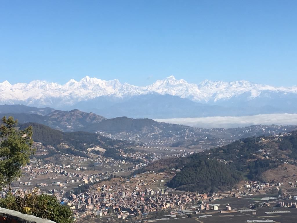 Vista panorámica de un pueblo con montañas nevadas al fondo.