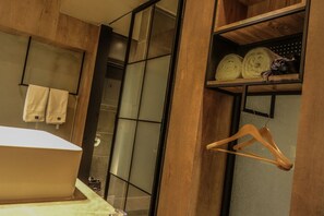 Ein Badezimmer mit einem Holzkosmetikschrank, einem Handtuchhalter und einem Regal mit Handtüchern und einem Holzaufhänger.