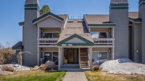 A two-story building with a balcony, a front door, and a number '588-591' displayed above the entrance. - Condo with Mountain Views! Shared Hot Tub! Shuttle Access! (Mammoth Lakes)