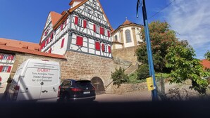 Un edificio tradicional con entramado de madera, pared de piedra y techo de tejas rojas.