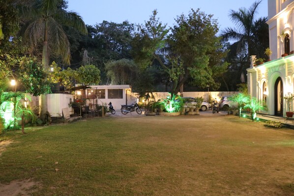 An outdoor area with a grassy lawn, a small building, and parked motorcycles.