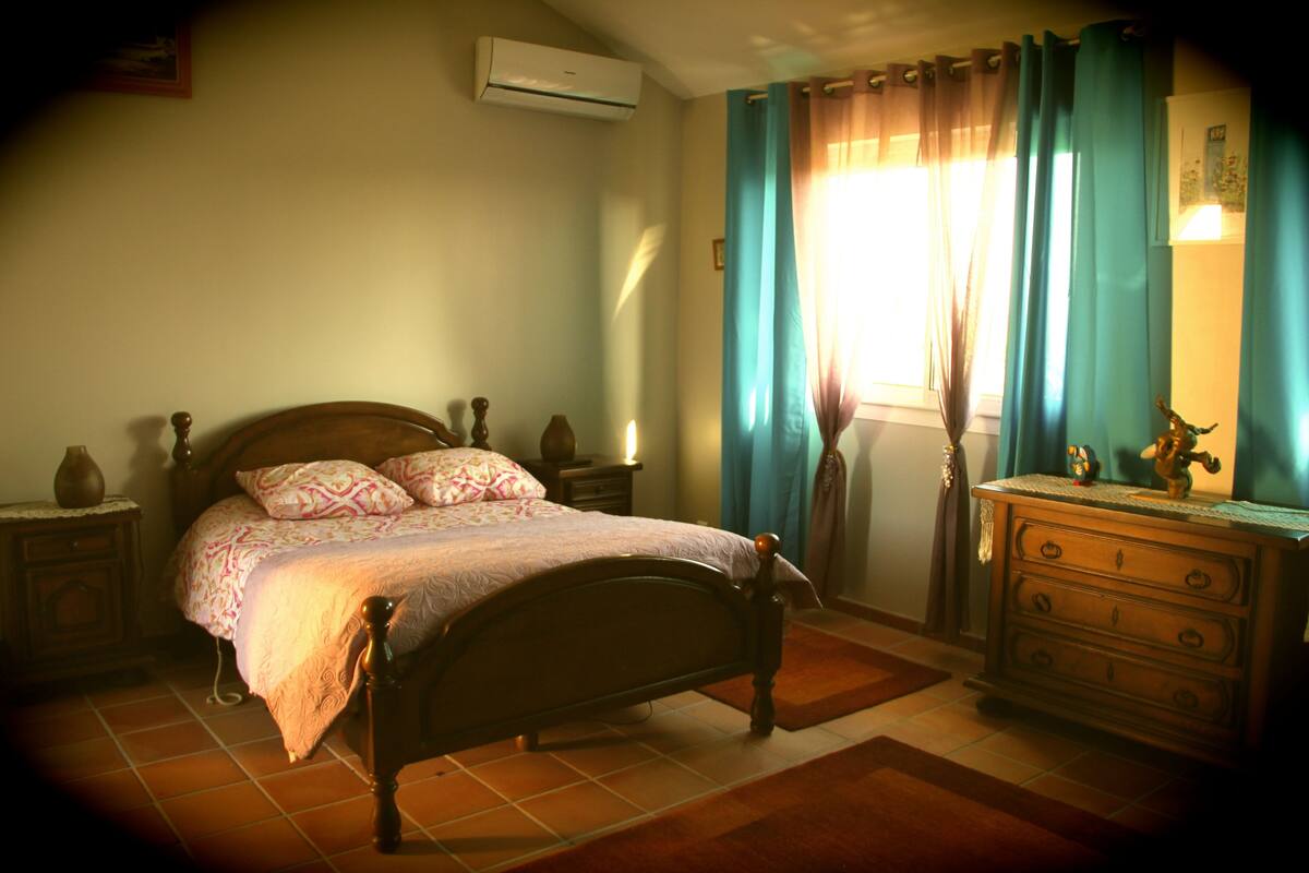 Ein Schlafzimmer mit Bett, Kommode und Nachttischen.