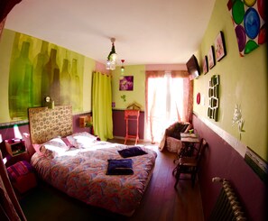 A bedroom with a bed, a chair, a small table, and a radiator. - Chateau Trillon (Sauternes)