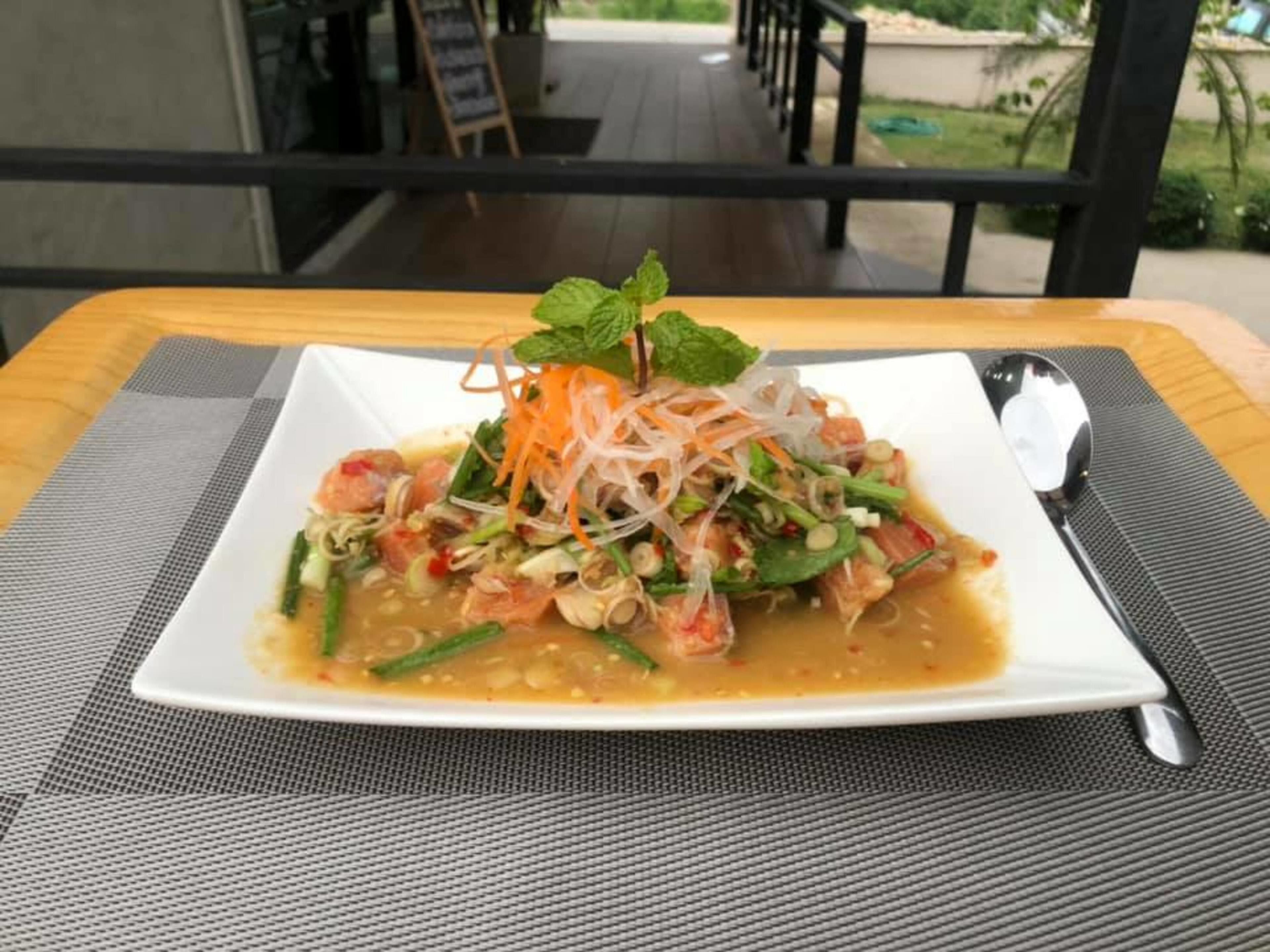 Ein Teller Essen auf einem Tisch mit Blick auf eine Terrasse und einen Außenbereich.