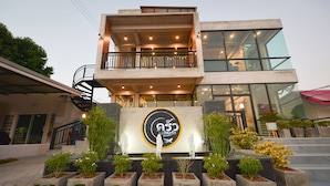 A modern building with a balcony, a welcome sign, and potted plants. - Muang Loei Airport Hotel (Mueang Loei)