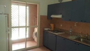 A kitchen with blue cabinets, a gas stove, and a sink.