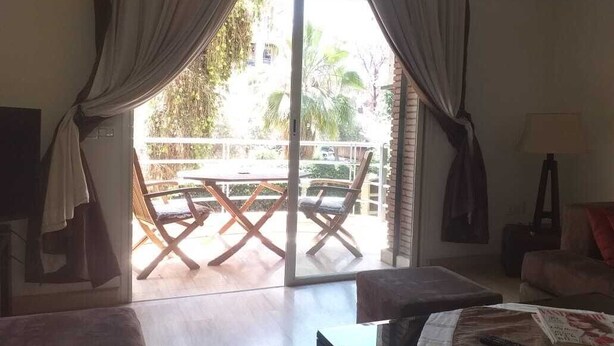A room with a sliding glass door leading to an outdoor patio area with a table and chairs.