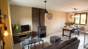 Ein Wohnzimmer mit Fernseher, Kamin, Sofa und Essbereich.