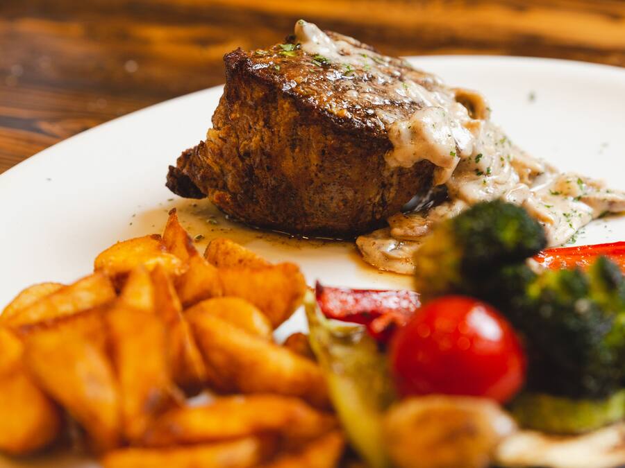 A plate with a steak, fries, and vegetables.