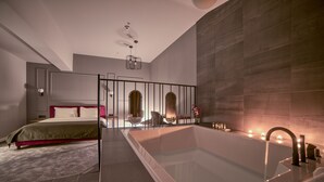 A modern bathroom with a large bathtub, a separate shower area, and a seating area with a view of the city. - Boscovich Boutique Hotel (Podgorica)