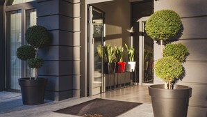 A modern building entrance with potted plants and a doormat. - Boscovich Boutique Hotel (Podgorica)