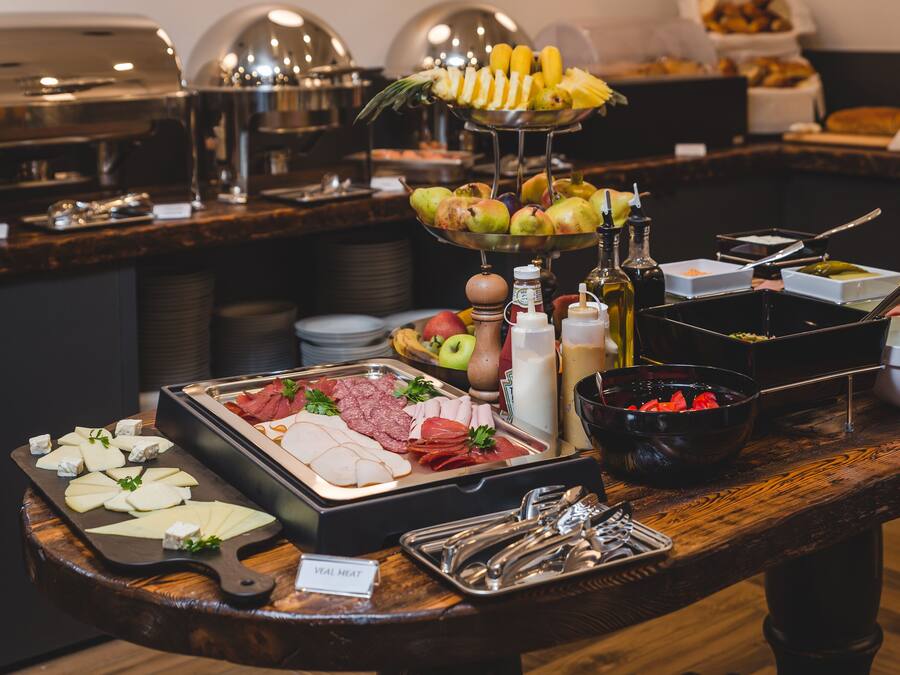 A buffet with various food items including fruits, cheeses, and meats.