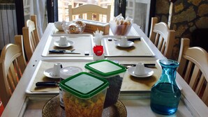 A dining table set with various items including a bowl of cookies, a glass vase, and containers with food items. - La Casetta (Palermo)