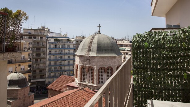 A view of a cityscape with a prominent building featuring a dome and a cross on top, surrounded by multi-story residential buildings. - Sunny & Happy Apartment Historic Center (Thessaloniki)