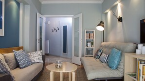 A living room with a sofa, a coffee table, and a bookshelf. - Sunny & Happy Apartment Historic Center (Thessaloniki)