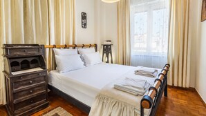 Een keurig opgemaakt slaapkamer met een houten bed, een kaptafel en een nachtkastje.