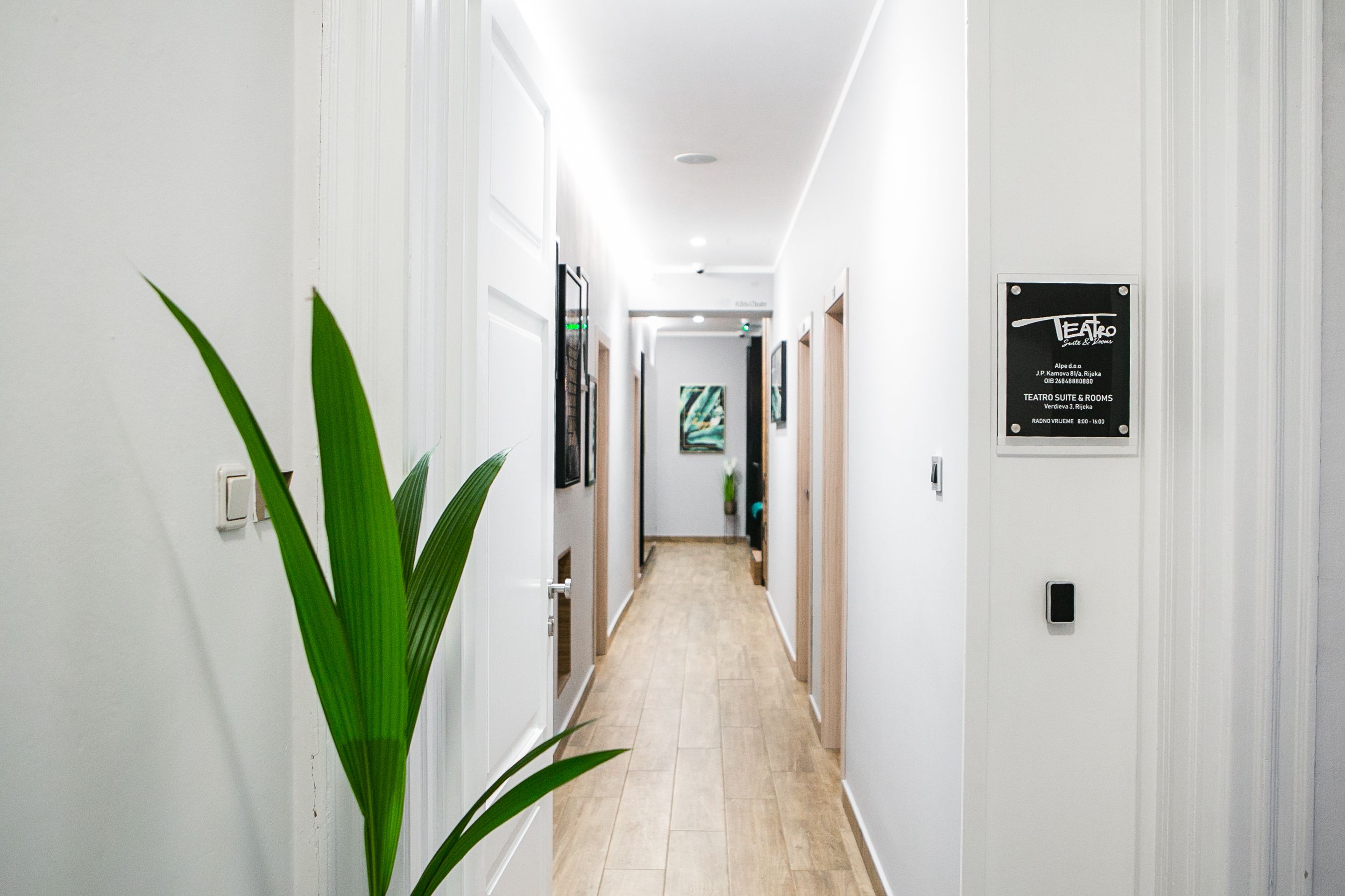 A clean, well-lit hallway with a sign indicating a theater suite and rooms.