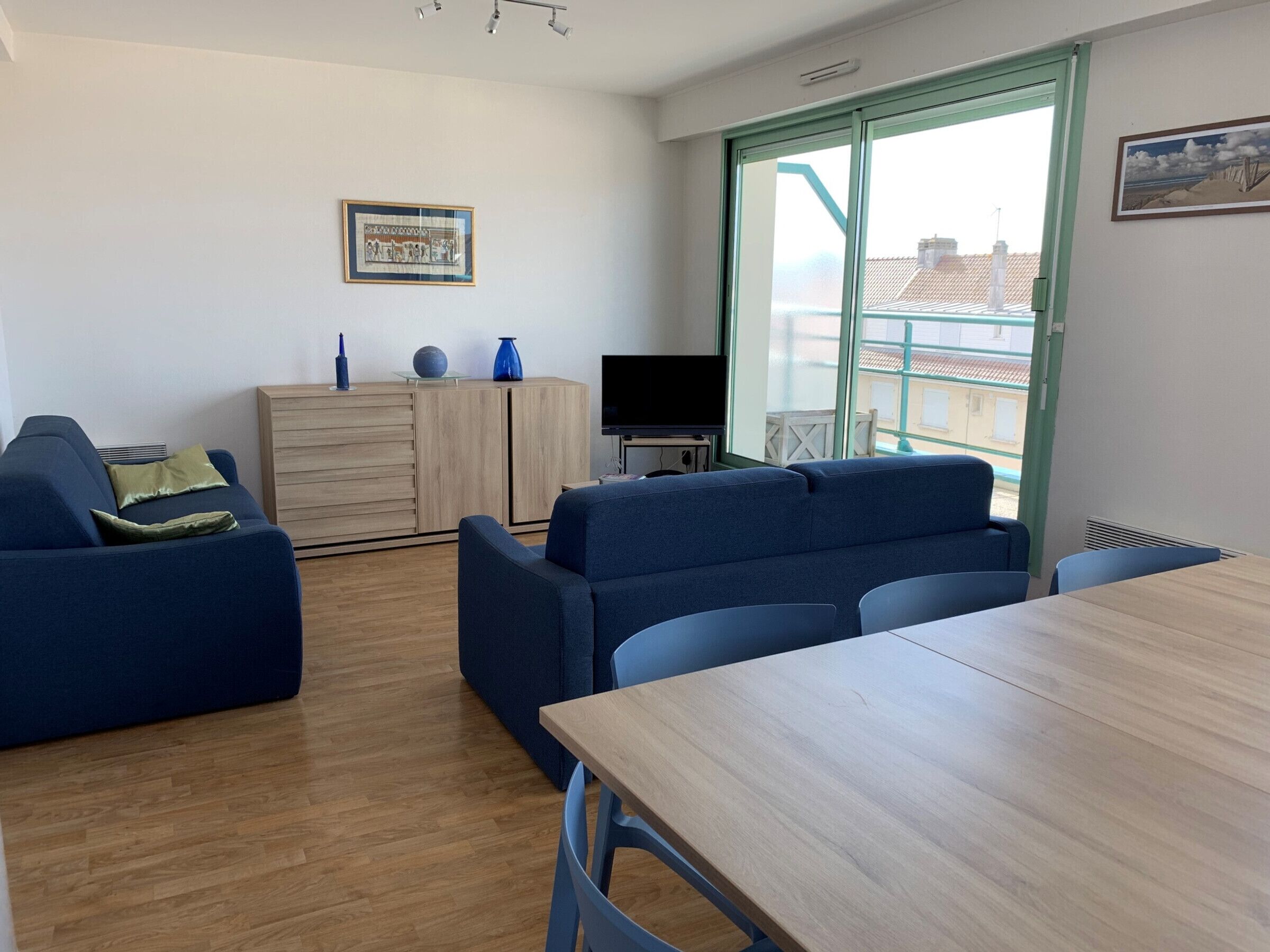 Ein modernes Wohnzimmer mit einer Couch, einem Esstisch und einem Fernseher.