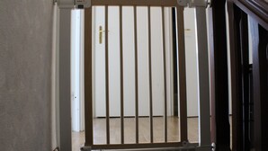 Una escalera de madera con una reja metálica en la parte superior.