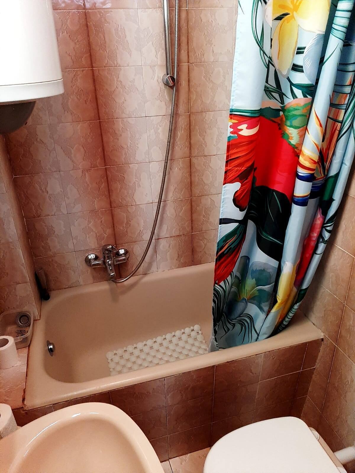 Un baño con bañera, ducha e inodoro.