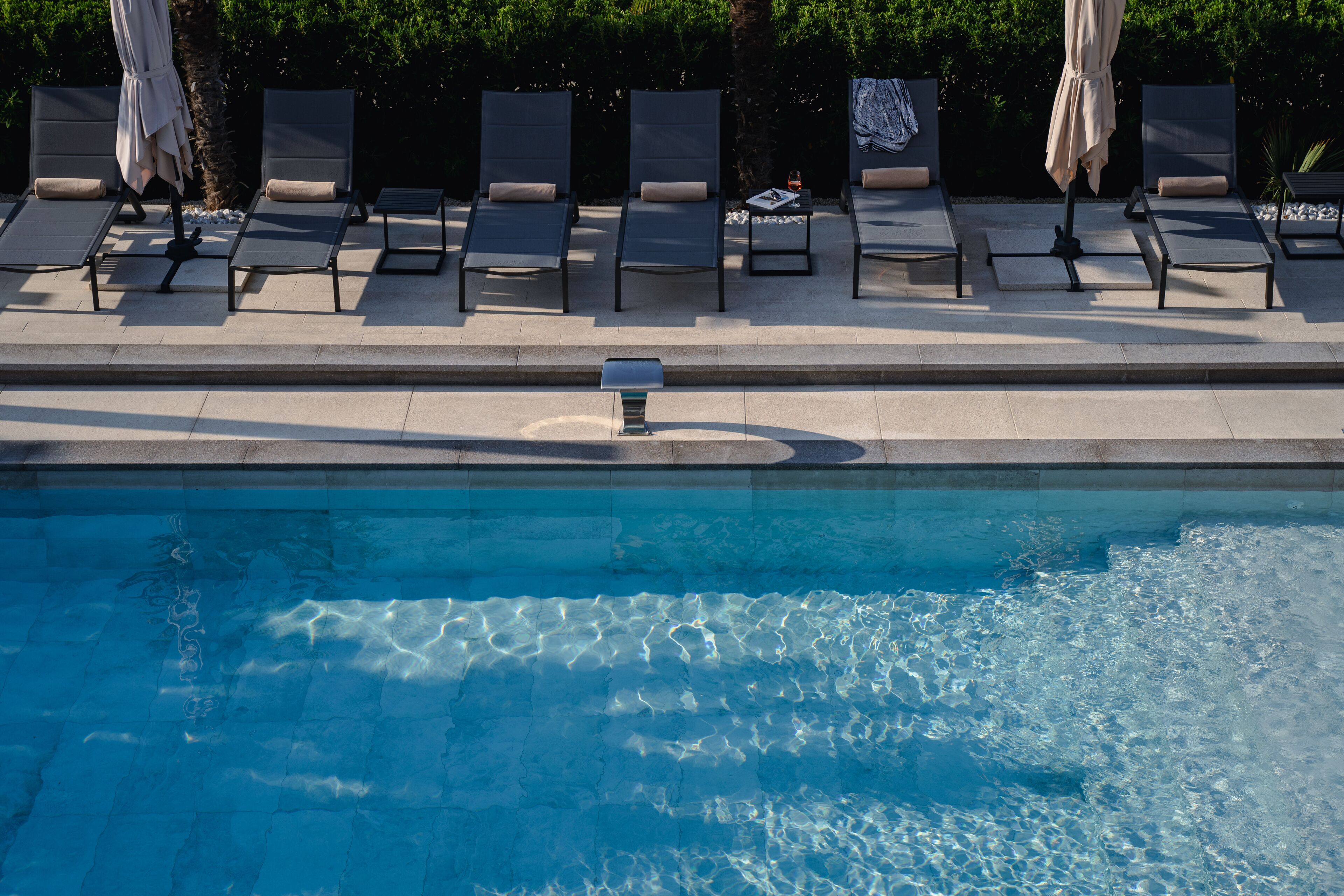 A poolside area with lounge chairs and umbrellas.