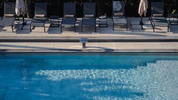 A poolside area with lounge chairs and umbrellas.