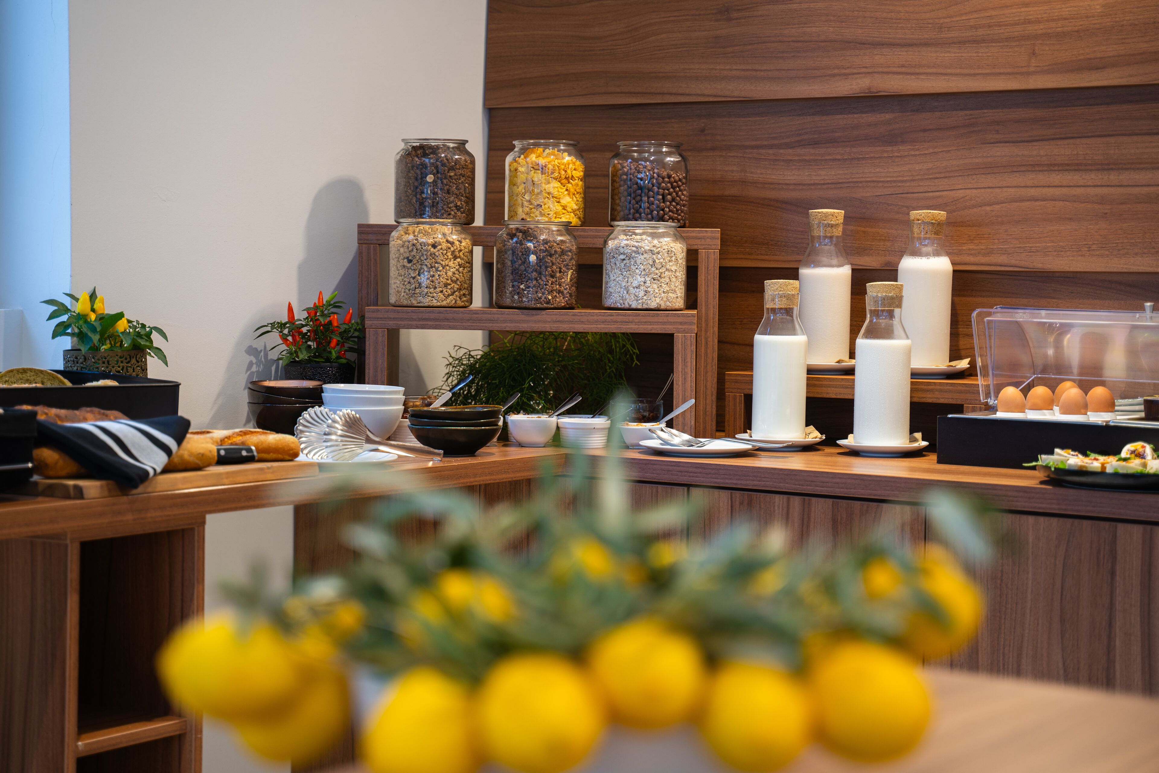 A breakfast bar with various food items, jars of grains, and a display of eggs.