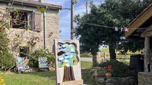 A stone pedestal with a colorful abstract sculpture in a garden setting. - Feng Shui Cottage in Marlhes' Nature (Marlhes)